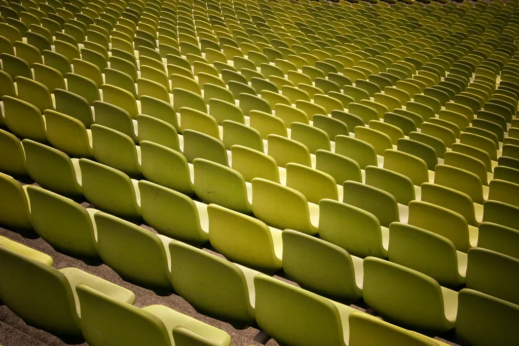 Rows of empty green seats in an auditorium
