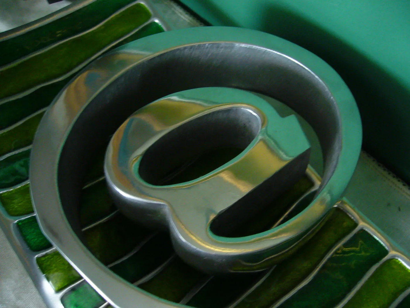 Close view of a metal at symbol on a green keyboard