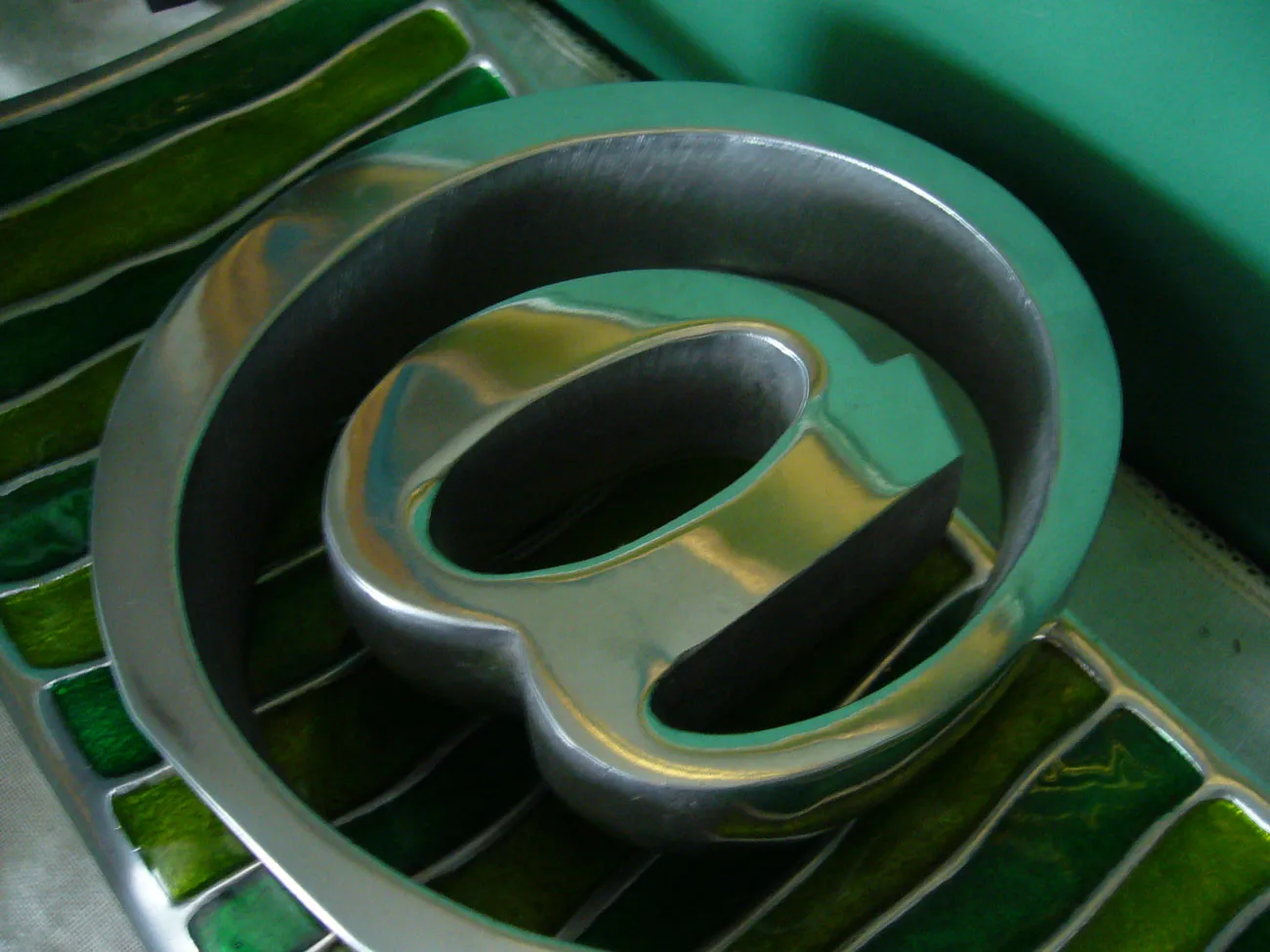 Close view of a metal at symbol on a green keyboard