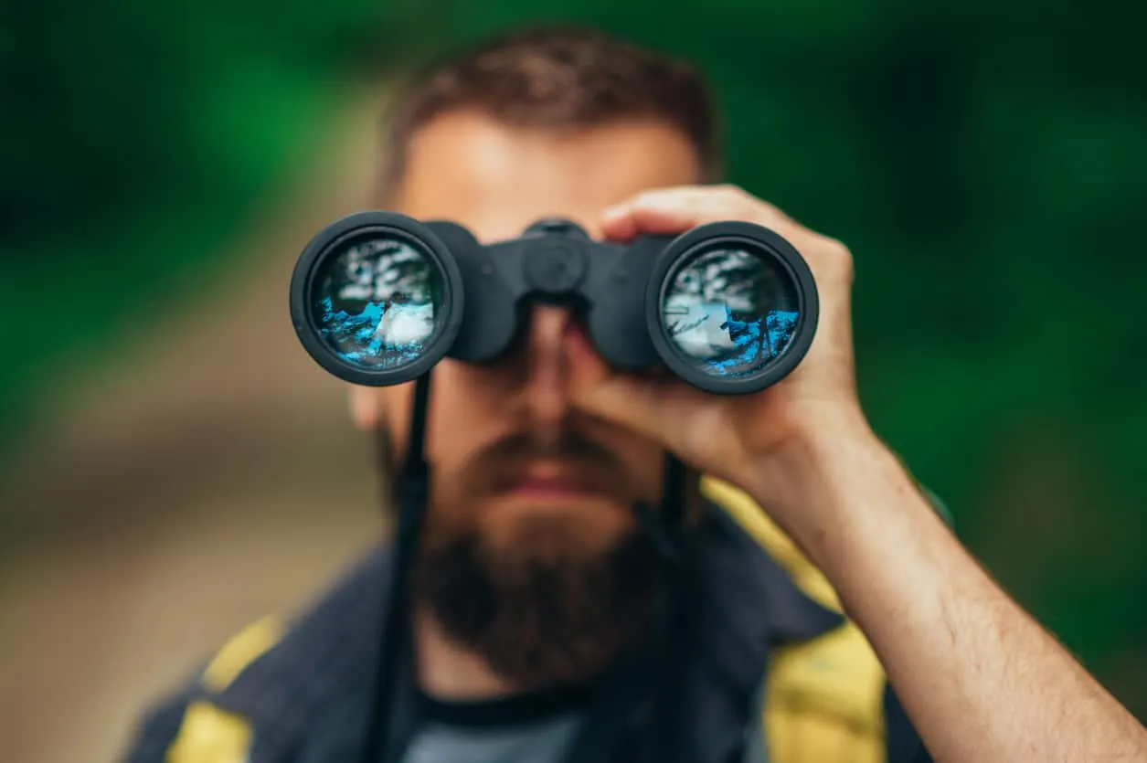 A man looking through binoculars