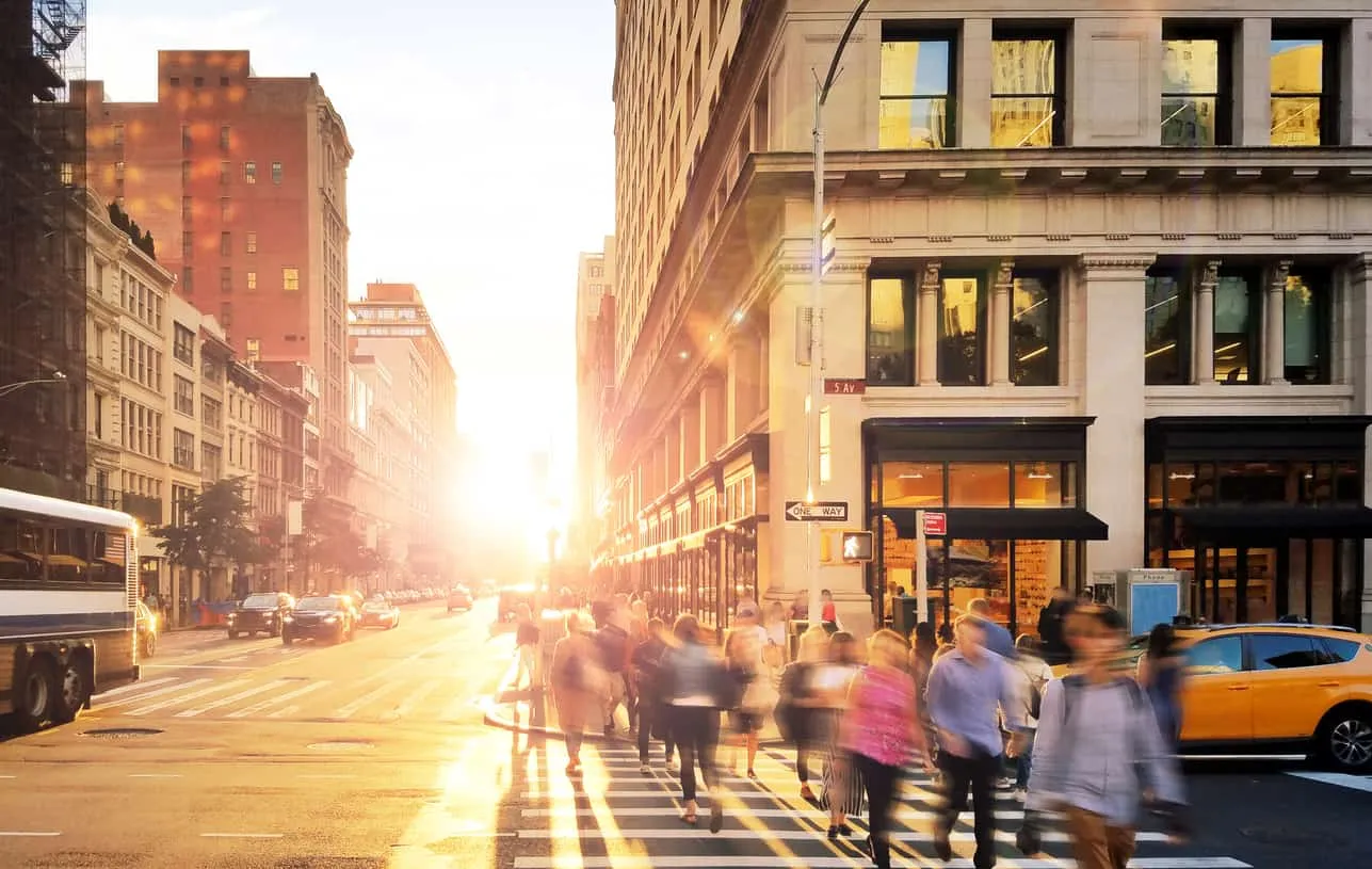 Commuters crossing a city street at sunrise, motion blurred