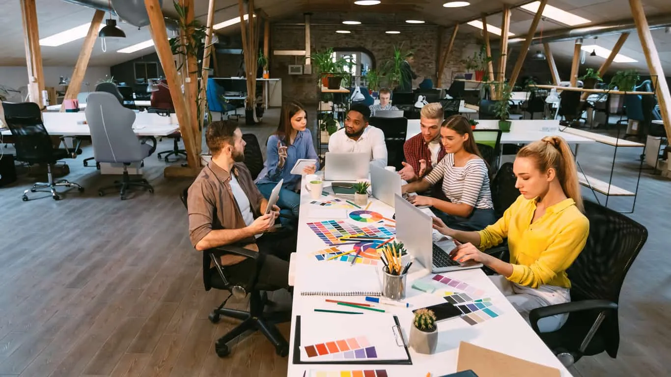 A team working together at a long desk in a bright open office