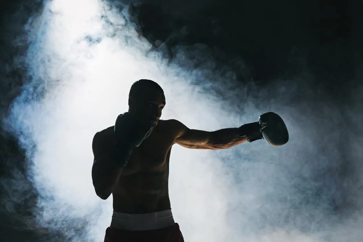 Silhouette of a boxer throwing a punch against a smoky background