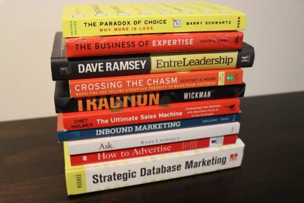 A stack of marketing and business books including Traction, Inbound Marketing and The Paradox of Choice