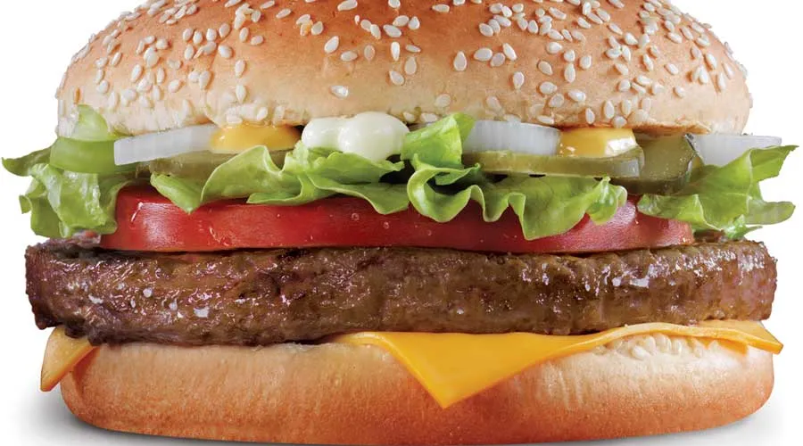 A cheeseburger with lettuce, tomato and pickles on a sesame bun