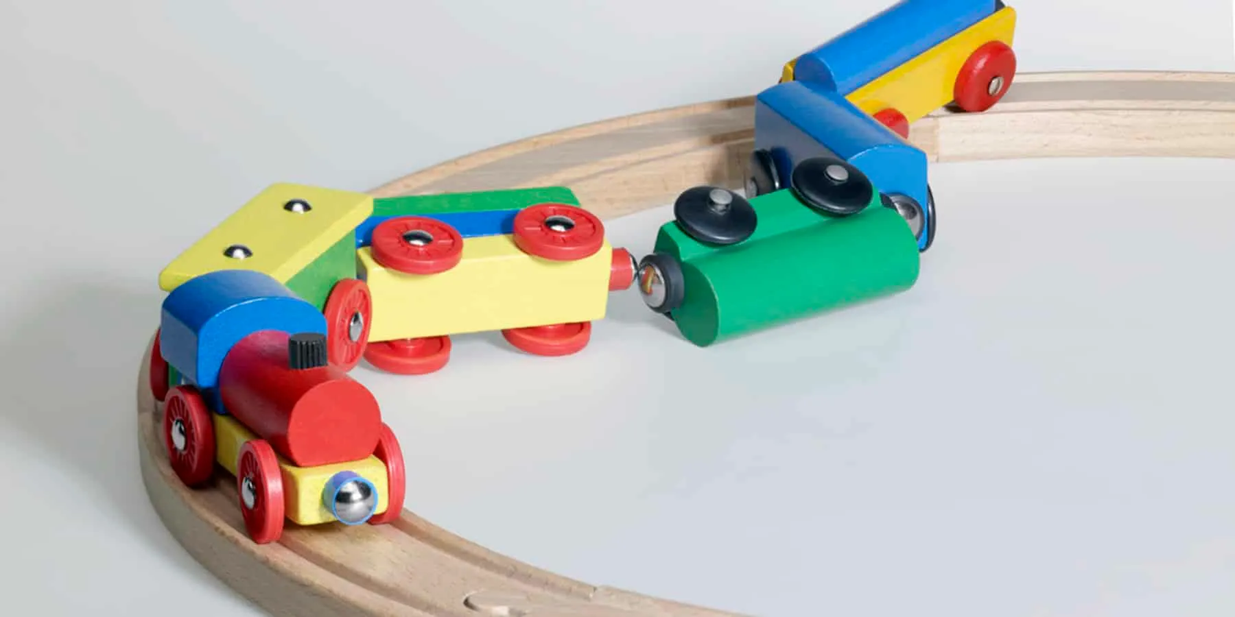 A wooden toy train derailed off its track