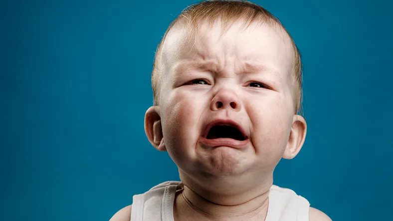 A crying baby against a blue background
