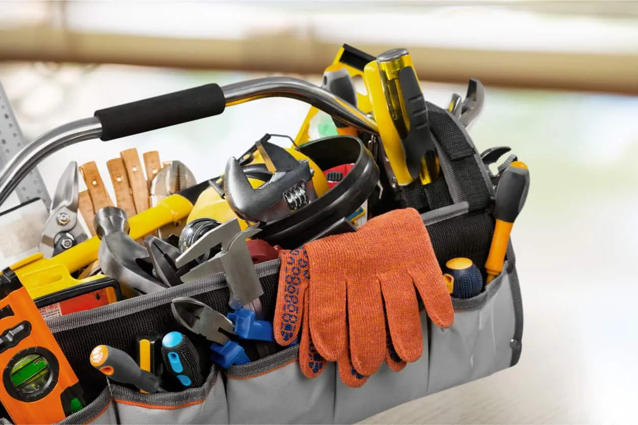 An open tool bag packed with hand tools and a pair of work gloves