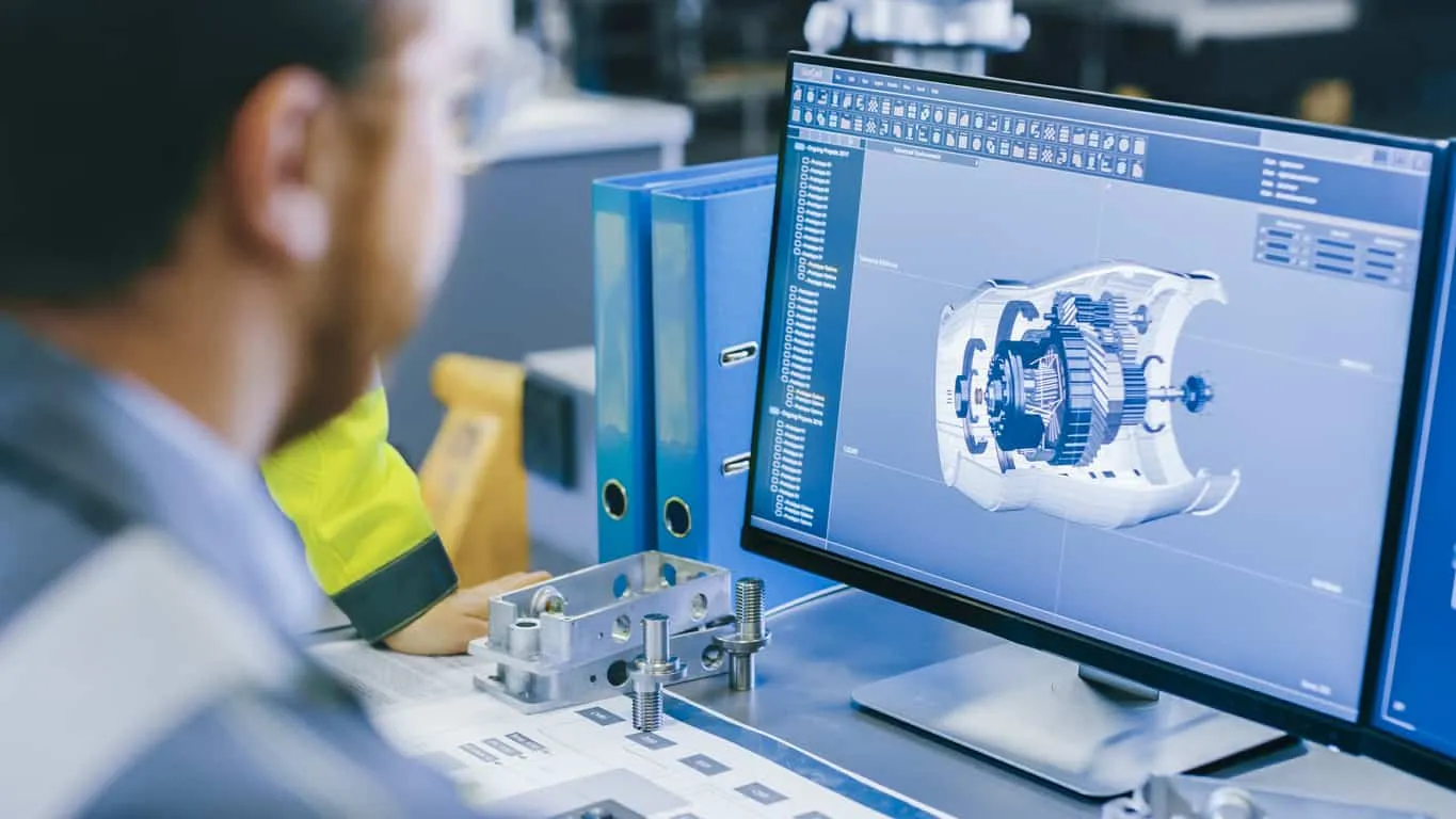 An engineer at a workstation viewing a 3D component model on screen