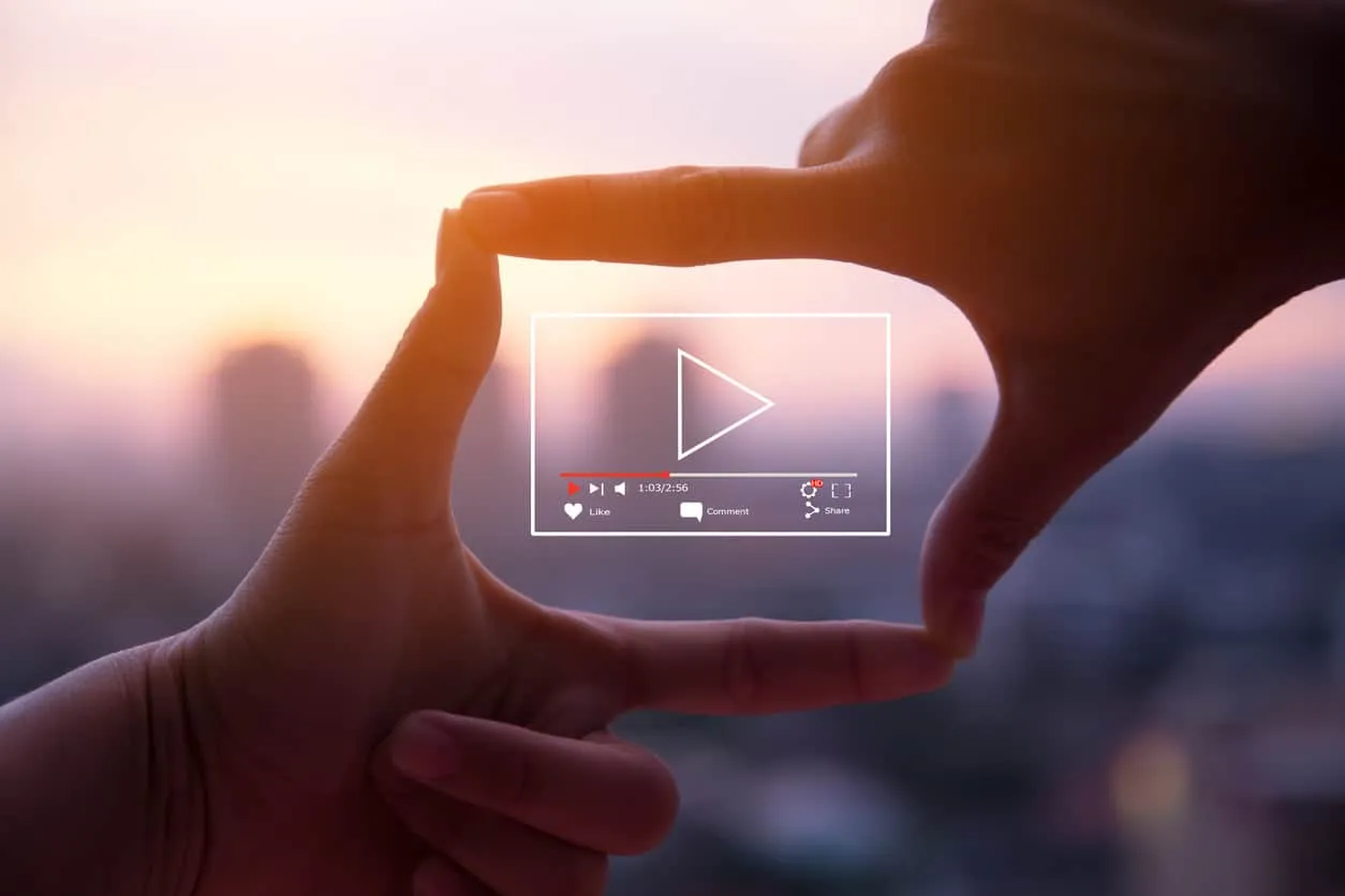 Hands framing a video player interface against a blurred skyline