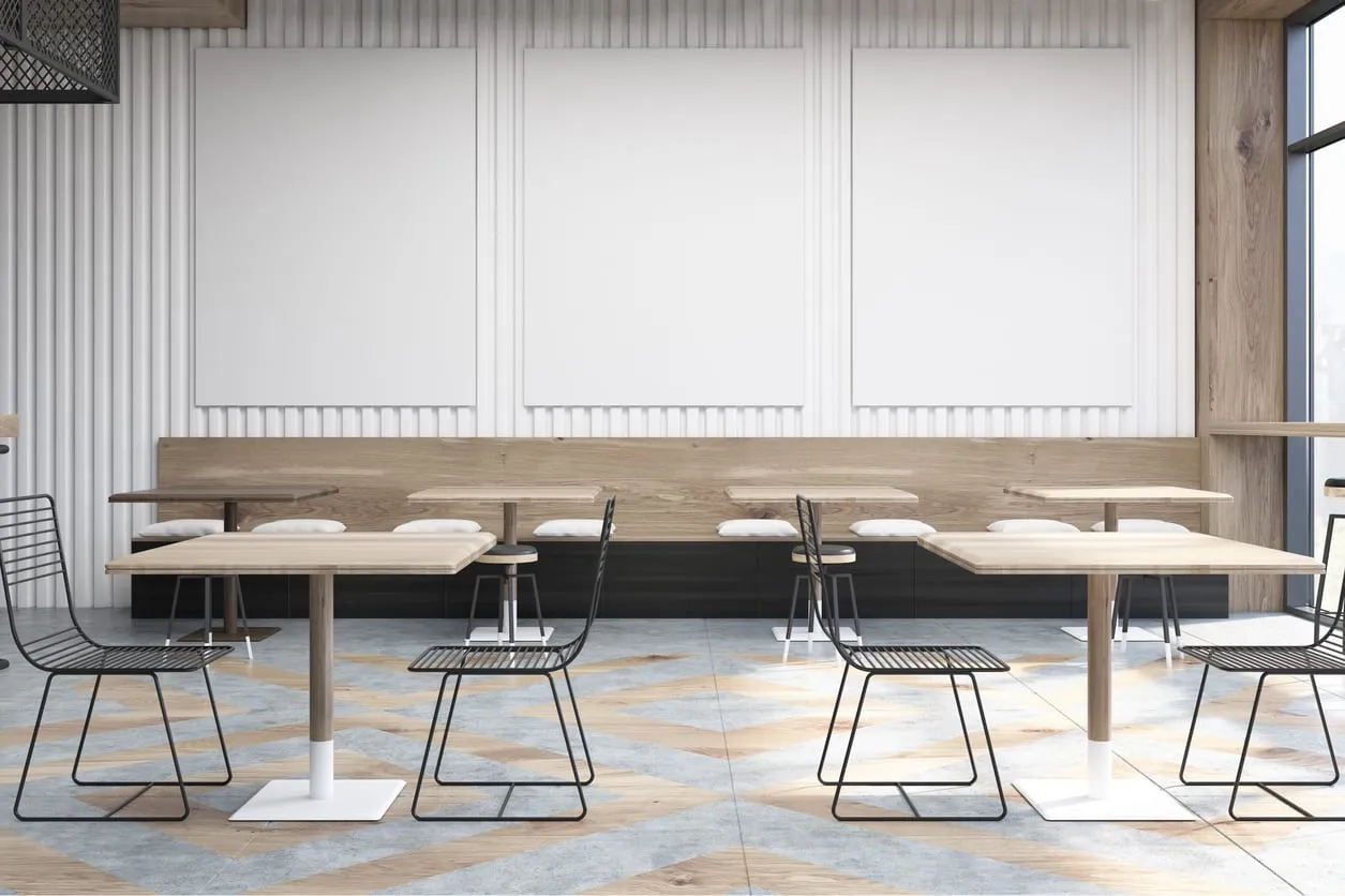 An empty cafe with long tables and wire chairs