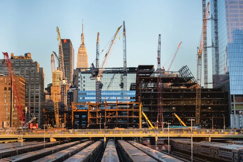 A city construction site with tower cranes against a skyline