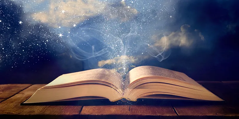 An open book on a table with light and stars rising from its pages