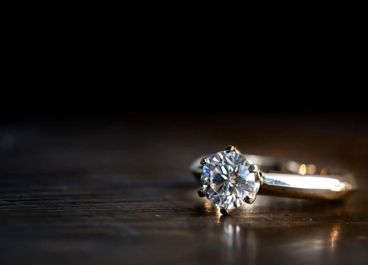 A diamond ring on a dark surface