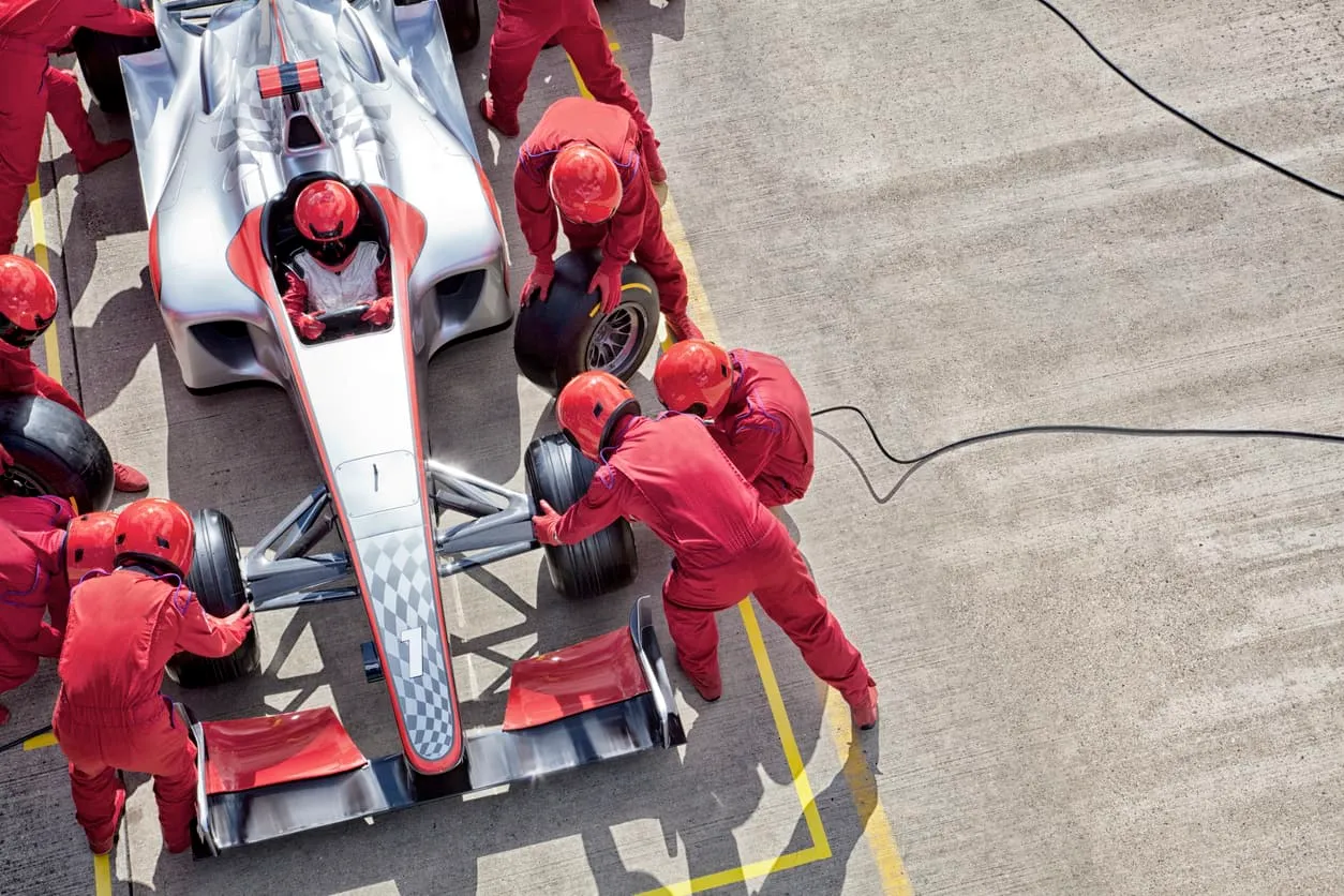Overhead view of a pit crew working on a racing car during a stop