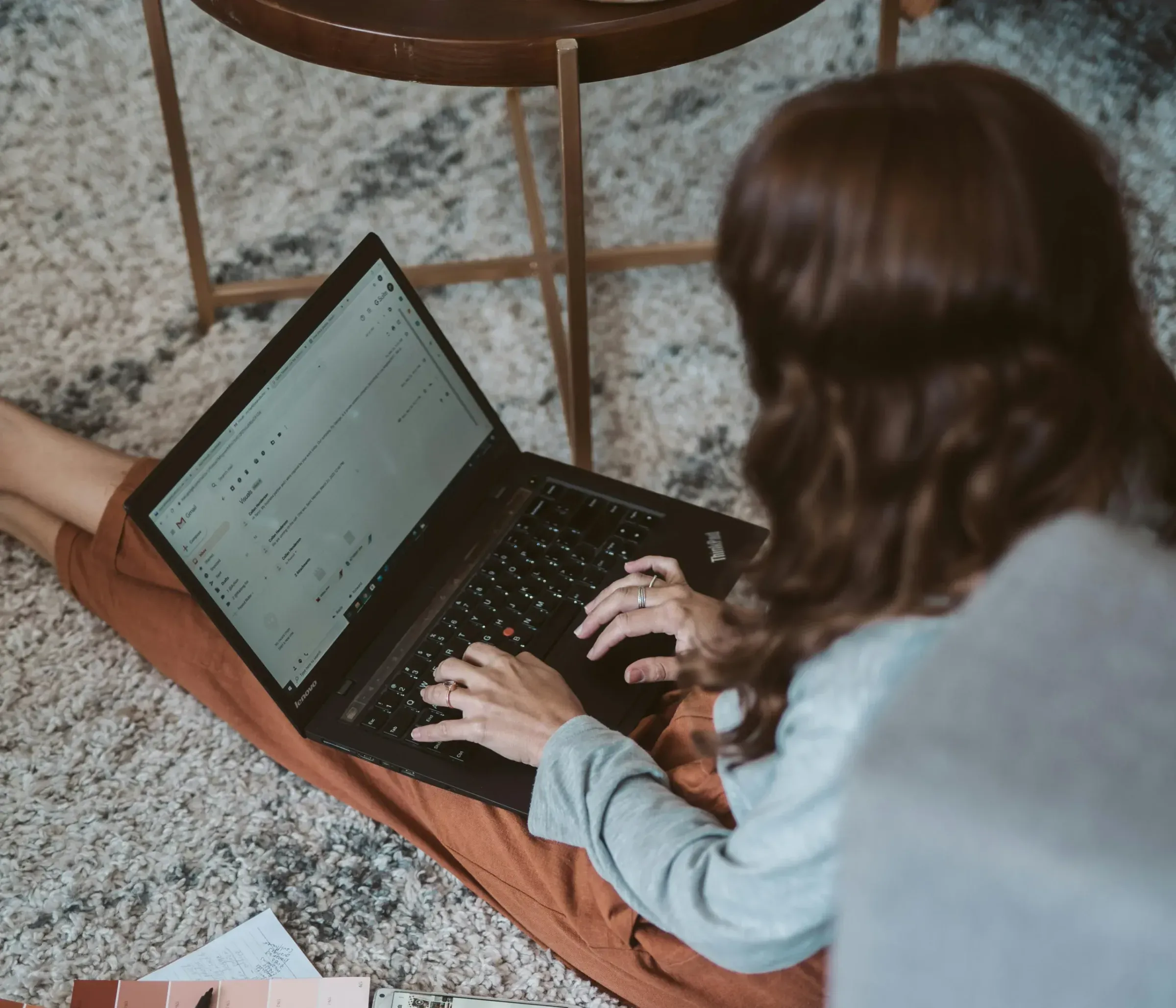 A woman working at a laptop on her lap
