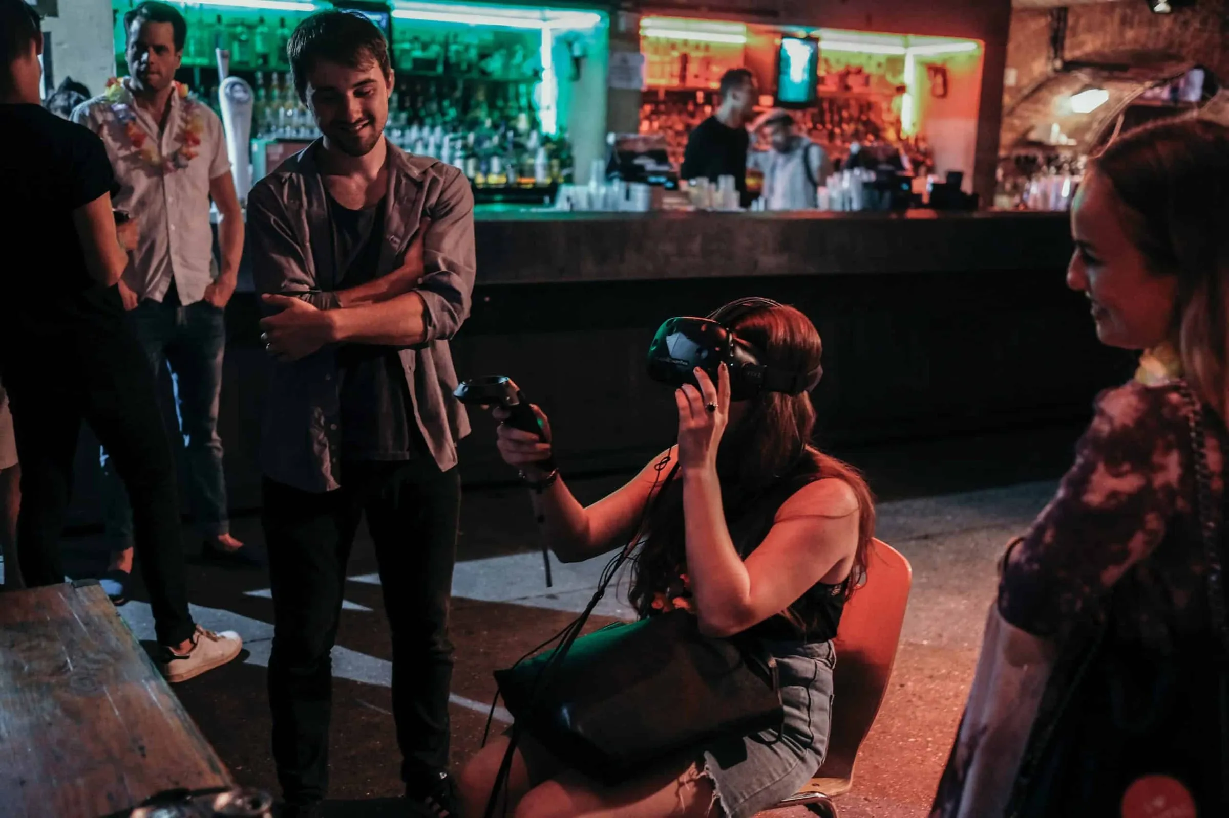 A camera operator filming a woman in a busy bar