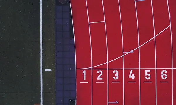 Overhead view of a running track with the numbered starting lanes one to six