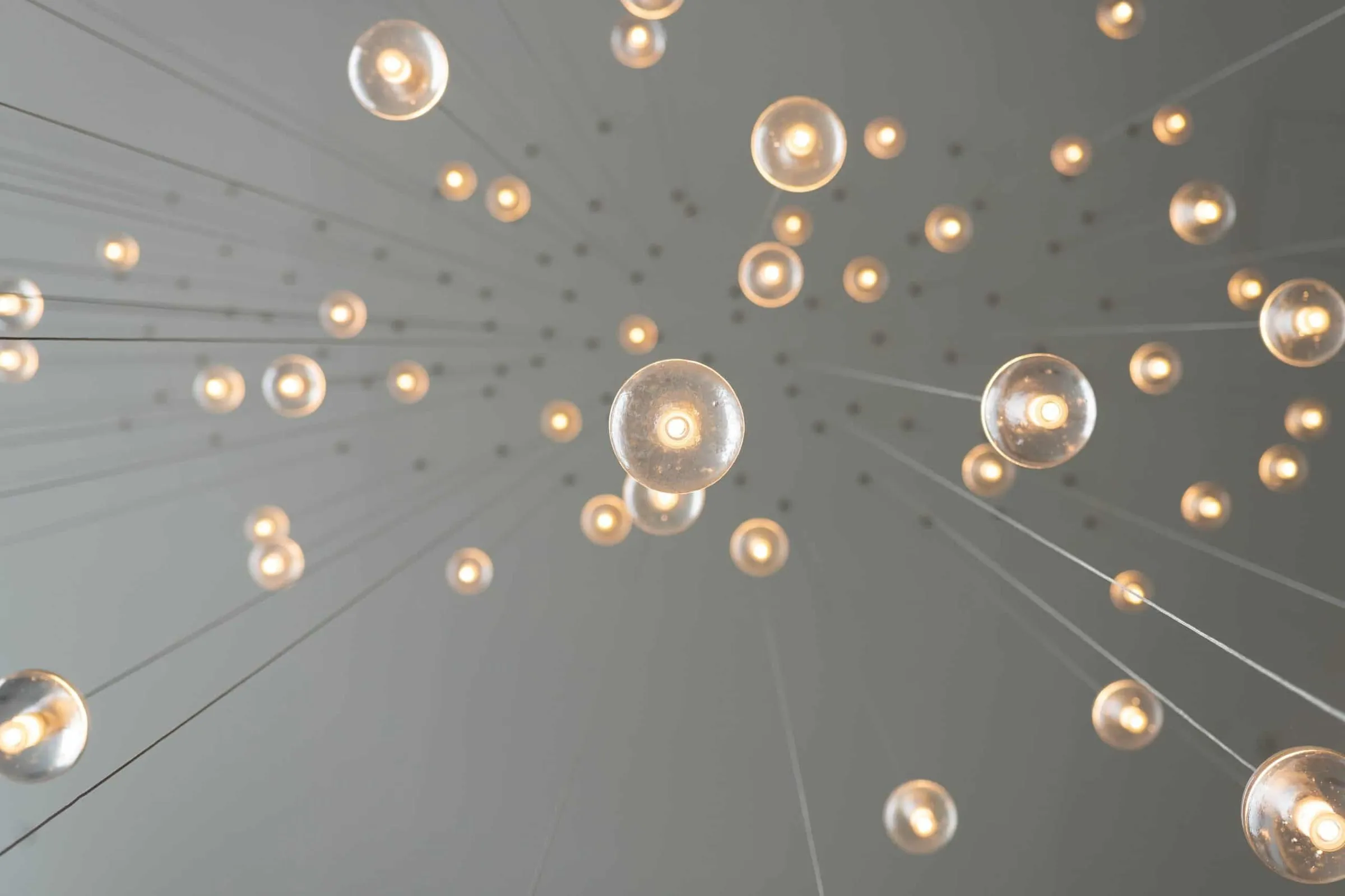 Pendant lights hung at different heights against a grey ceiling
