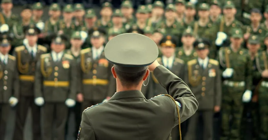 An officer saluting a formation of soldiers
