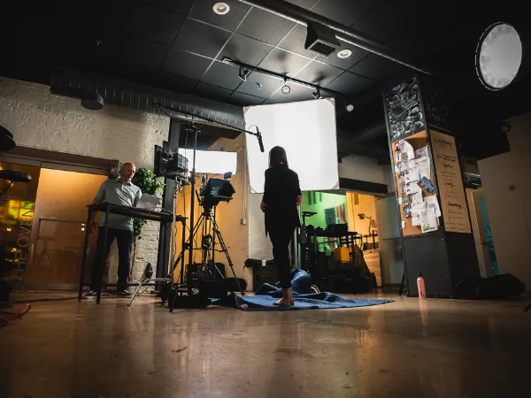 A film crew shooting an interview on a lit studio set
