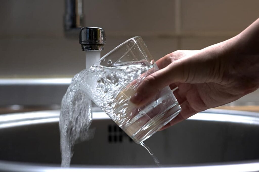 over filling glass of water in hand